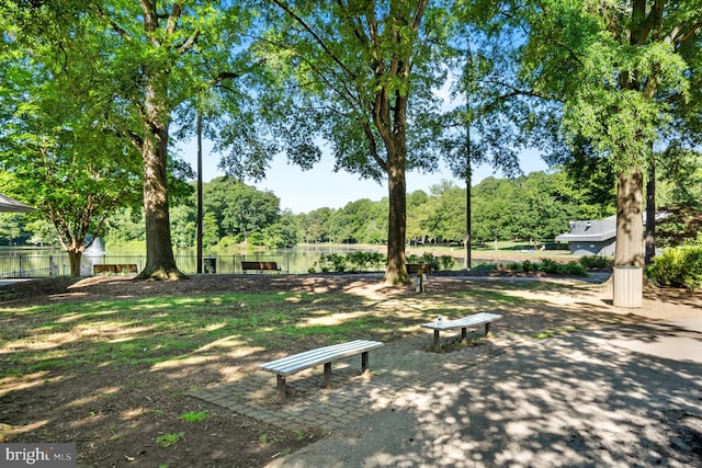 view of home's community featuring fence and a water view