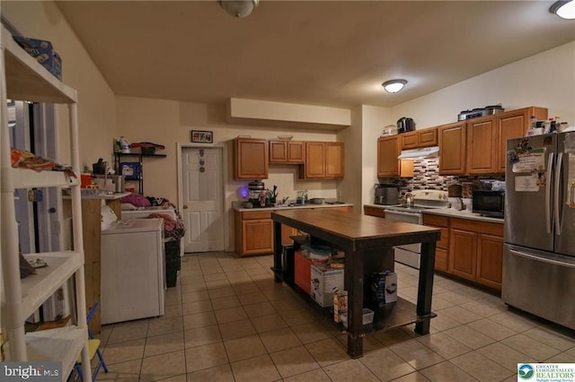 kitchen with freestanding refrigerator, under cabinet range hood, light tile patterned floors, and electric stove