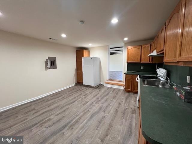kitchen featuring light wood finished floors, freestanding refrigerator, recessed lighting, baseboards, and under cabinet range hood
