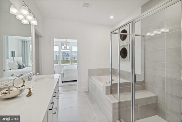 ensuite bathroom with vanity, tile patterned flooring, a stall shower, and ensuite bath