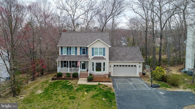 view of front of house featuring an attached garage, a shingled roof, aphalt driveway, and covered porch