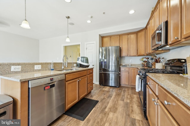 207 Community Center Ave Unit 207, Gaithersburg, MD 20878 - kitchen featuring pendant lighting, appliances with stainless steel finishes, light wood-type flooring, a sink, and an island with sink
