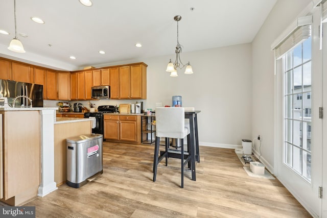 207 Community Center Ave Unit 207, Gaithersburg, MD 20878 - kitchen featuring light countertops, hanging light fixtures, appliances with stainless steel finishes, and light wood finished floors
