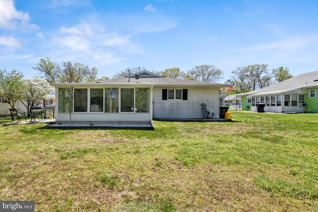 back of house with a yard and a sunroom