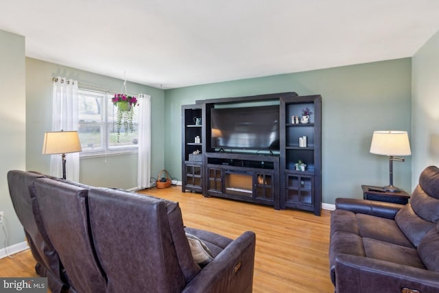living area with baseboards and wood finished floors