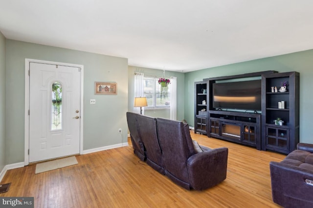 living room featuring baseboards, wood finished floors, and visible vents