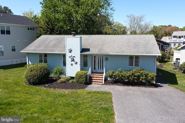 708 Radial Dr, Bethany Beach, DE 19930 - single story home with roof with shingles, fence, a front yard, and a chimney