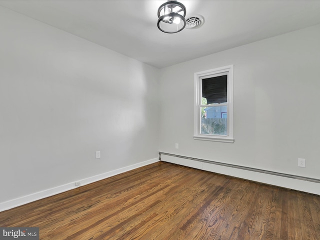 unfurnished room featuring baseboards, dark wood finished floors, baseboard heating, and visible vents