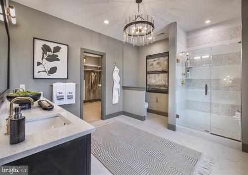 full bathroom featuring a shower stall, vanity, toilet, a notable chandelier, and recessed lighting