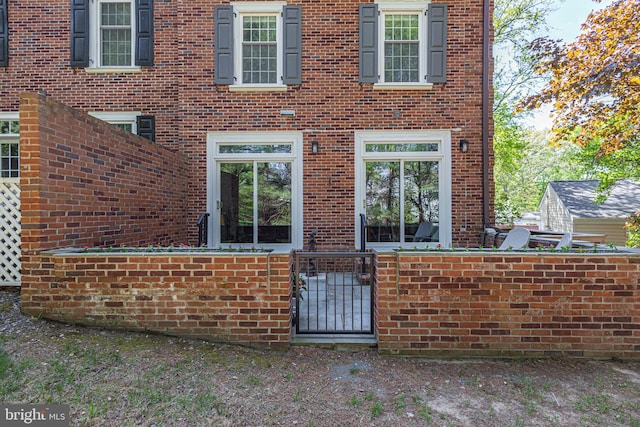 exterior space with brick siding, a fenced front yard, and a gate