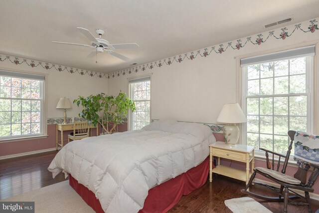 bedroom featuring baseboards, ceiling fan, wood-type flooring, and visible vents