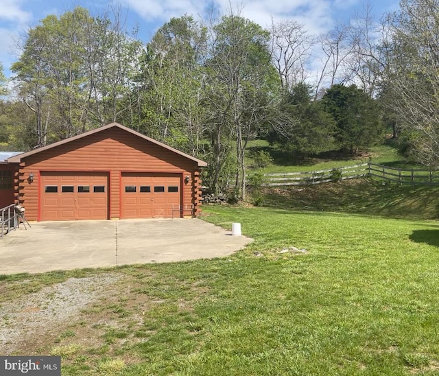 detached garage with fence and driveway