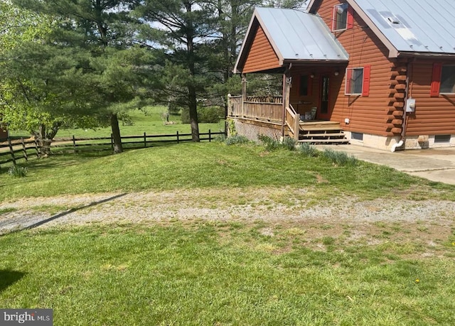 view of side of home featuring fence, log siding, a yard, and metal roof