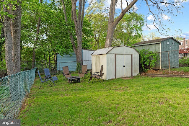 view of shed featuring a fenced backyard and an outdoor fire pit
