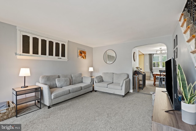 living room featuring arched walkways and carpet floors