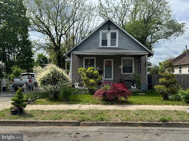 bungalow with covered porch and fence