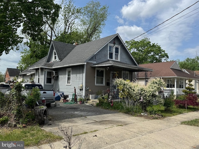 bungalow-style house with concrete driveway and roof with shingles