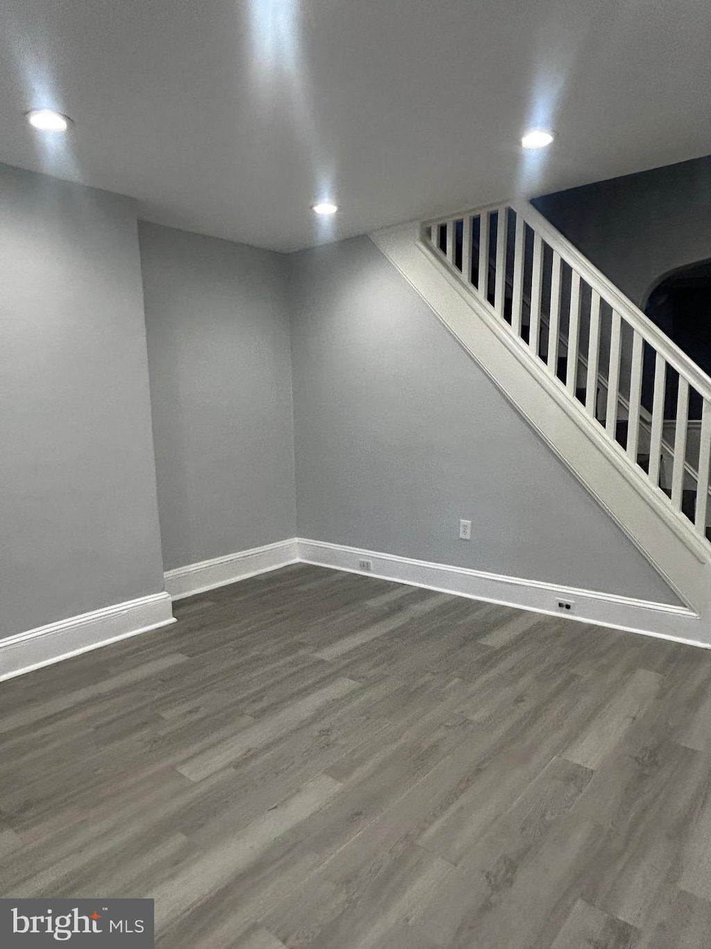 finished basement with recessed lighting, baseboards, stairway, and dark wood-style flooring