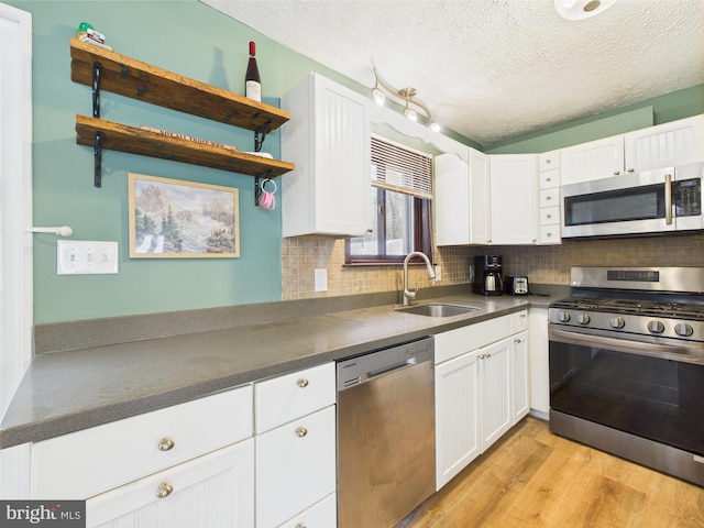 4105 Wilcox Ct, Pocono Lake, PA 18347 - kitchen featuring dark countertops, white cabinets, appliances with stainless steel finishes, and a sink