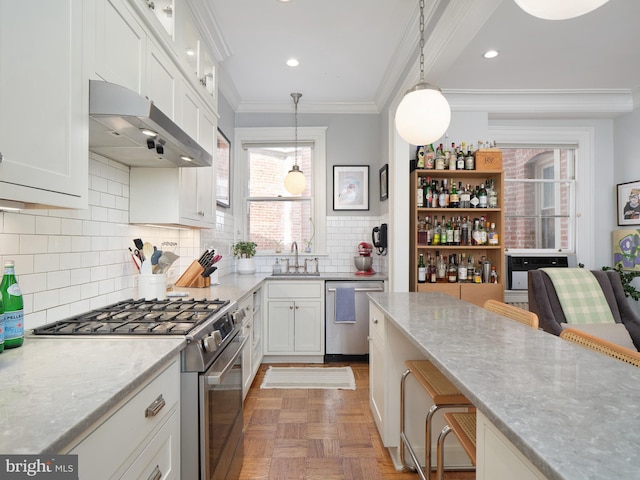 kitchen with ornamental molding, light stone countertops, extractor fan, a sink, and appliances with stainless steel finishes