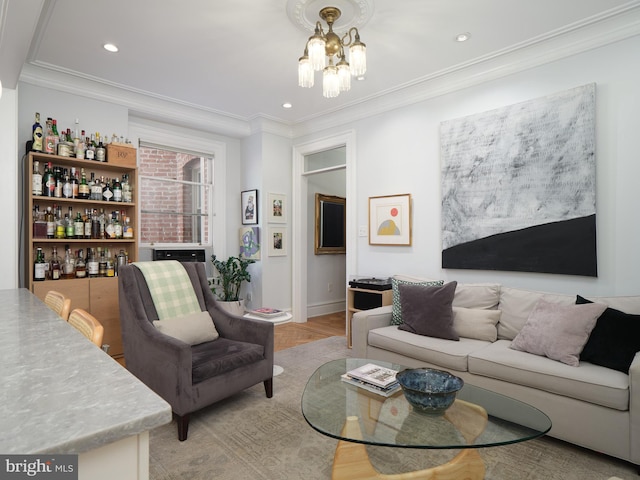 living area featuring crown molding, baseboards, recessed lighting, a chandelier, and a bar