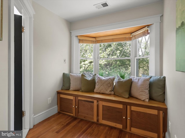 sitting room with visible vents, baseboards, and wood finished floors
