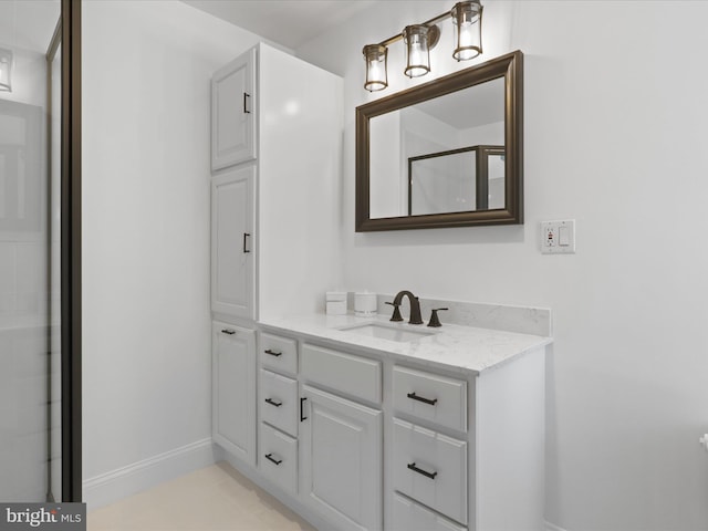 bathroom featuring vanity, baseboards, and an enclosed shower
