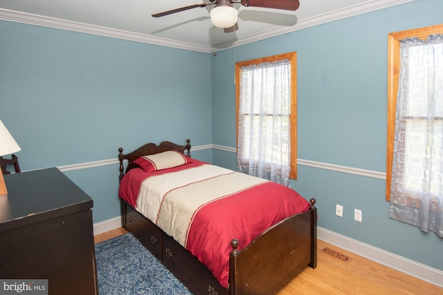 bedroom featuring visible vents, wood finished floors, and multiple windows