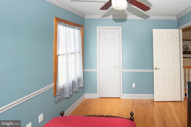 bedroom featuring crown molding, baseboards, and wood finished floors