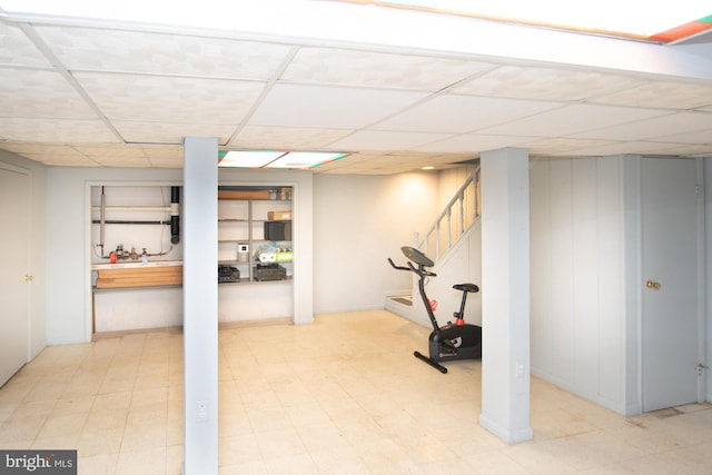 workout area with tile patterned floors and a paneled ceiling