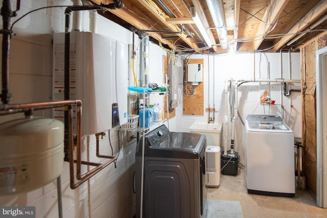 laundry room featuring a sink, tankless water heater, laundry area, and washer and clothes dryer