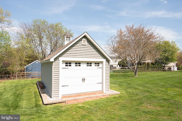 garage with fence and a shed
