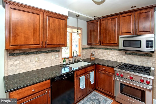 kitchen with a sink, dark stone countertops, decorative backsplash, and stainless steel appliances