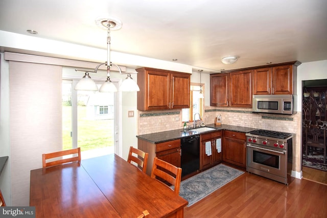 kitchen featuring decorative backsplash, brown cabinets, a sink, stainless steel appliances, and dark wood-type flooring
