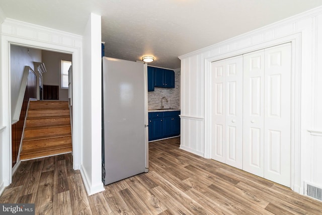 1414 Simpson St, Marcus Hook, PA 19061 - interior space with crown molding, freestanding refrigerator, a sink, dark wood-style floors, and blue cabinets