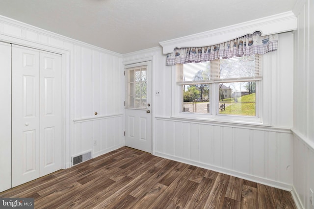 1414 Simpson St, Marcus Hook, PA 19061 - unfurnished dining area featuring dark wood-style flooring, visible vents, ornamental molding, and a decorative wall