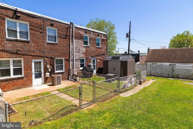 1414 Simpson St, Marcus Hook, PA 19061 - back of house featuring a lawn, a gate, brick siding, a fenced backyard, and a shed
