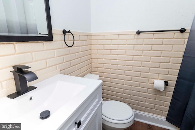 1414 Simpson St, Marcus Hook, PA 19061 - half bathroom with vanity, a wainscoted wall, toilet, and tile walls