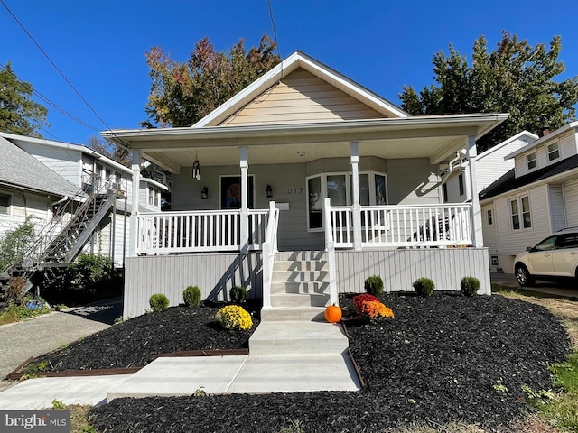 bungalow-style home featuring covered porch and stairway