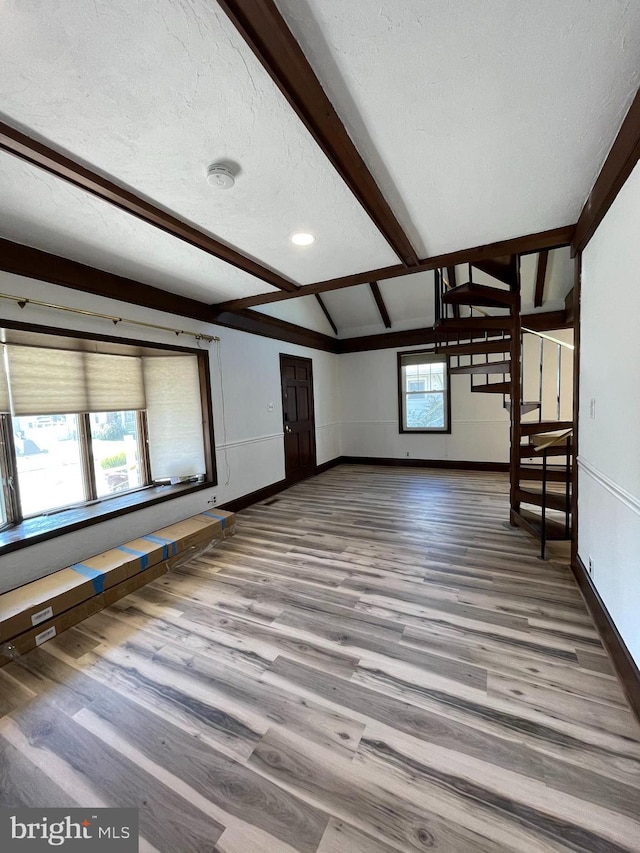 bonus room with baseboards, beamed ceiling, a textured ceiling, and wood finished floors
