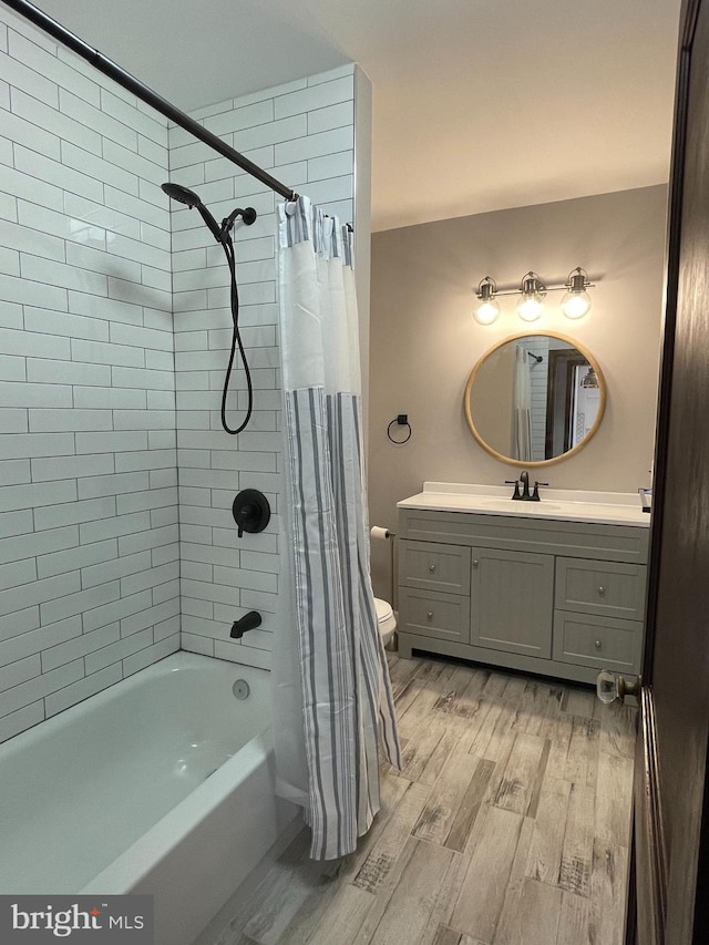 full bath featuring vanity, shower / bath combo, toilet, and wood finished floors