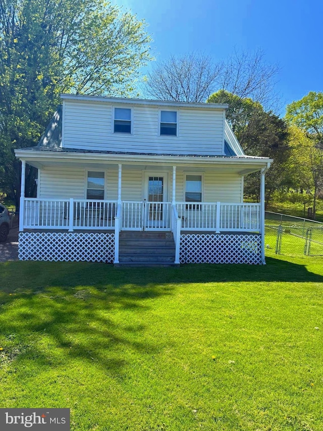 view of front of home with a porch, fence, and a front lawn
