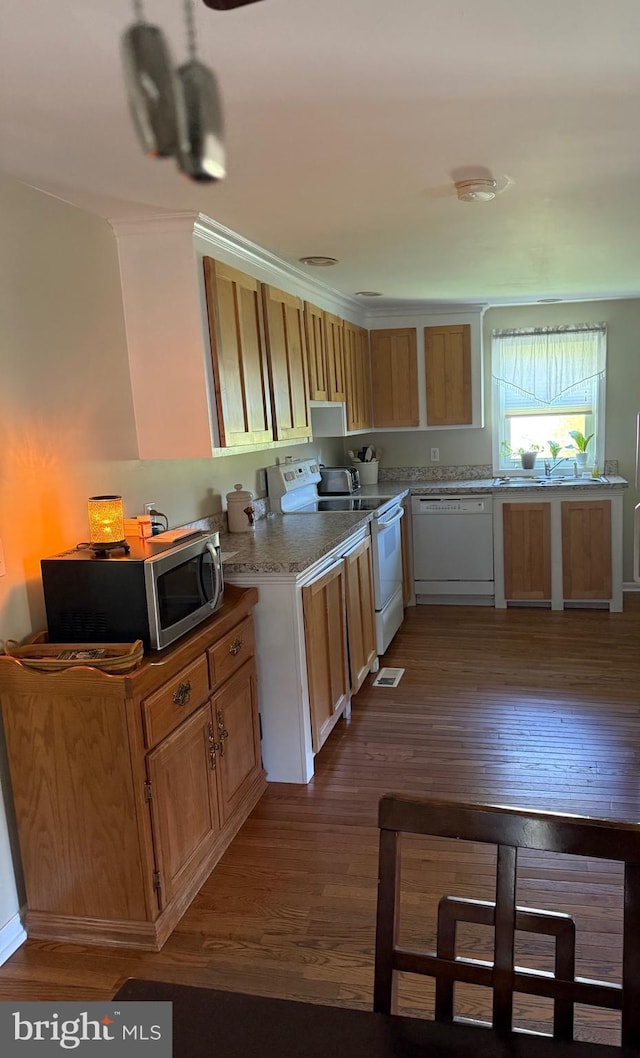 kitchen with light countertops, dark wood-style flooring, white appliances, and visible vents