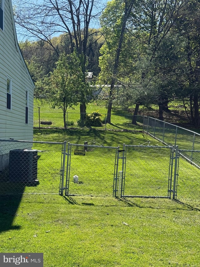 view of yard featuring central air condition unit, fence, and a gate