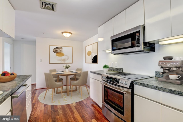 250 President St Unit 308, Baltimore, MD 21202 - kitchen featuring dark countertops, baseboards, white cabinets, stainless steel appliances, and dark wood-type flooring
