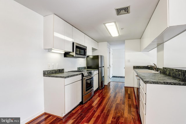 250 President St Unit 308, Baltimore, MD 21202 - kitchen with visible vents, dark wood-style flooring, dark countertops, a sink, and stainless steel appliances