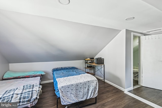 bedroom featuring baseboards, visible vents, wood finished floors, and lofted ceiling