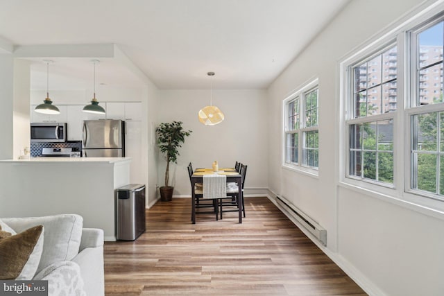 1240 Martha Custis Dr, Alexandria, VA 22302 - dining area featuring a baseboard heating unit, plenty of natural light, light wood-style floors, and baseboards