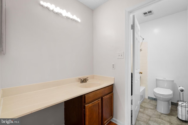 bathroom with vanity, toilet, and visible vents