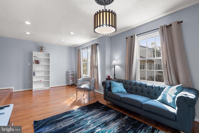 living area with a textured ceiling, wood finished floors, and a wealth of natural light
